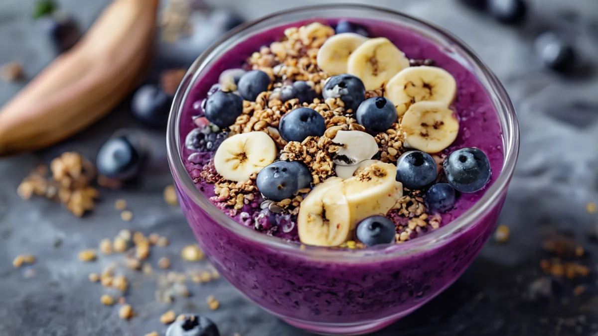 Um bolinho de açaí com frutas tropicais cortadas.